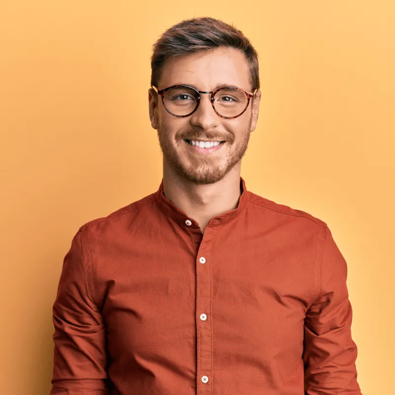 Man in glasses and red shirt smiling, testimonial photo