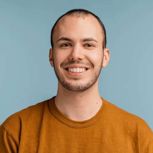 Confident man in a mustard shirt smiling, representing fast and friendly service